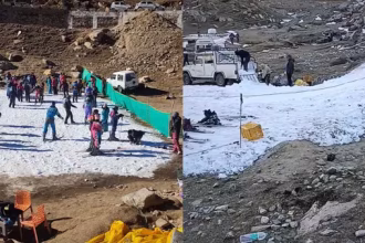 Turiști într-o stațiune montană cu un petic mic de zăpadă, în contrast cu terenul lipsit de ninsoare din jur