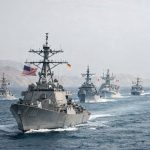 Allied naval vessels and commercial oil tankers in the Strait of Hormuz during the 2026 Gulf crisis, with flags of coalition member states represented among the warships present in the waterway