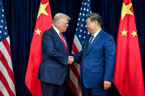 Donald Trump and Xi Jinping at the Beijing Summit, with U.S.-China tensions over Iran, Taiwan, the Strait of Hormuz, rare earths and global technology competition in the background.