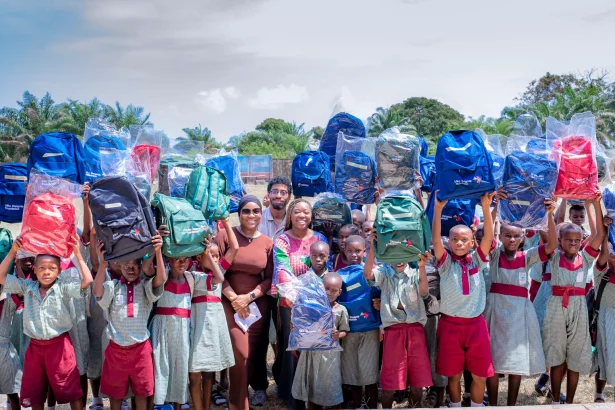 Aliko Dangote Foundation staff distributing branded school backpacks to uniformed primary school children in Nigeria