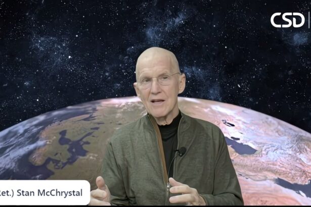 Retired General Stanley McChrystal speaking during a Center for the Study of Democracy event, with an image of Earth in the background.